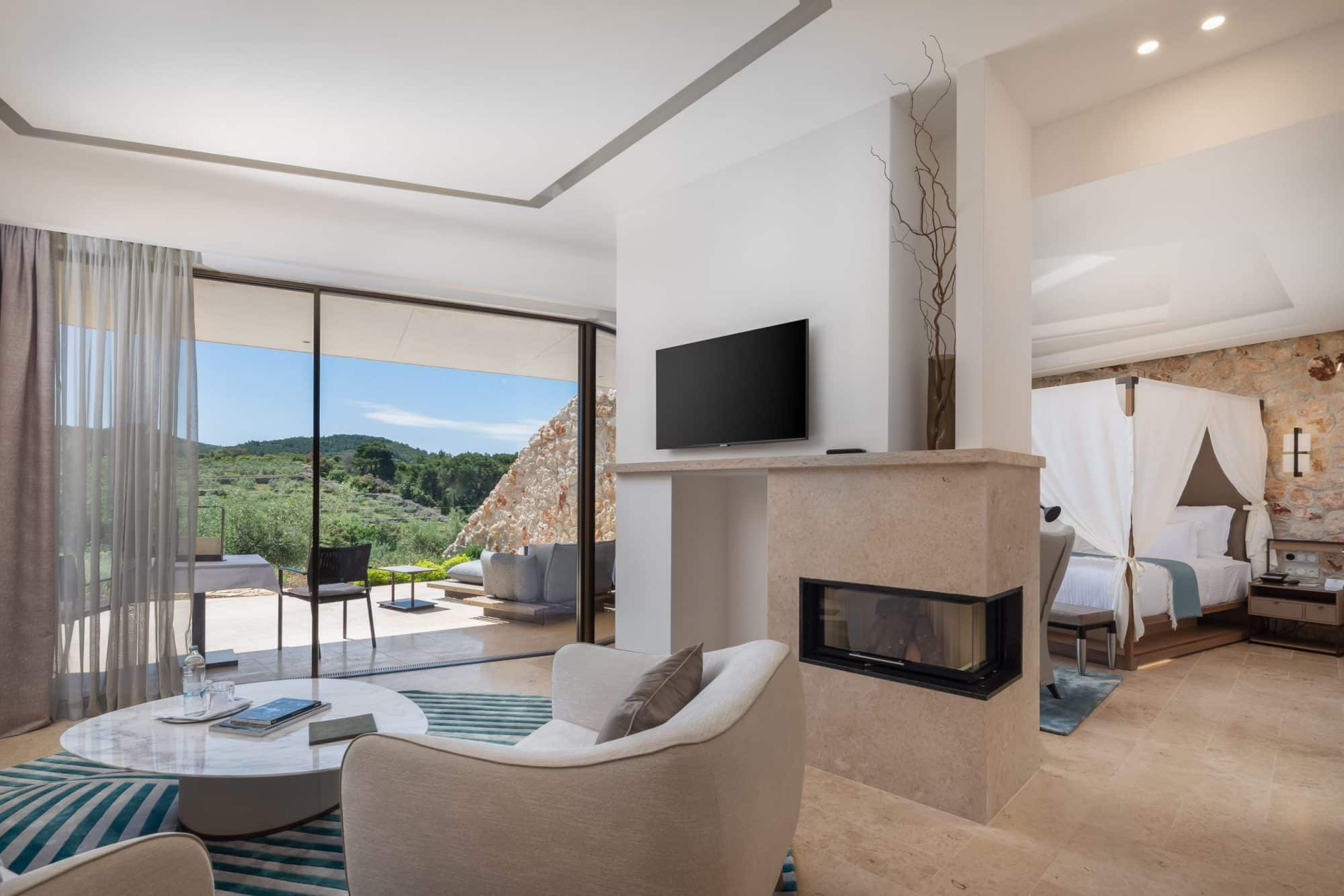 A suite opening through glass to a terrace and the olive groves