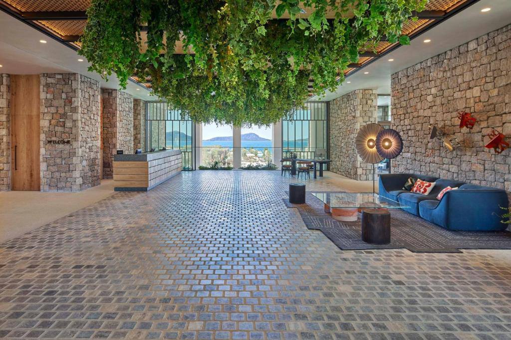 Lobby with hanging greenery, stone walls and a view to Navarino Bay