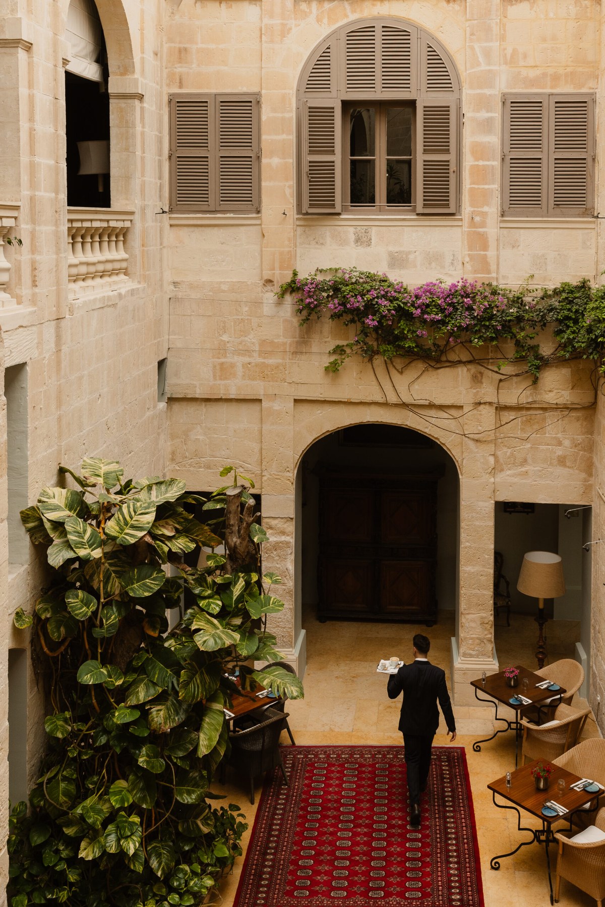 The palazzo's internal courtyard, with baroque arches and a stone stair