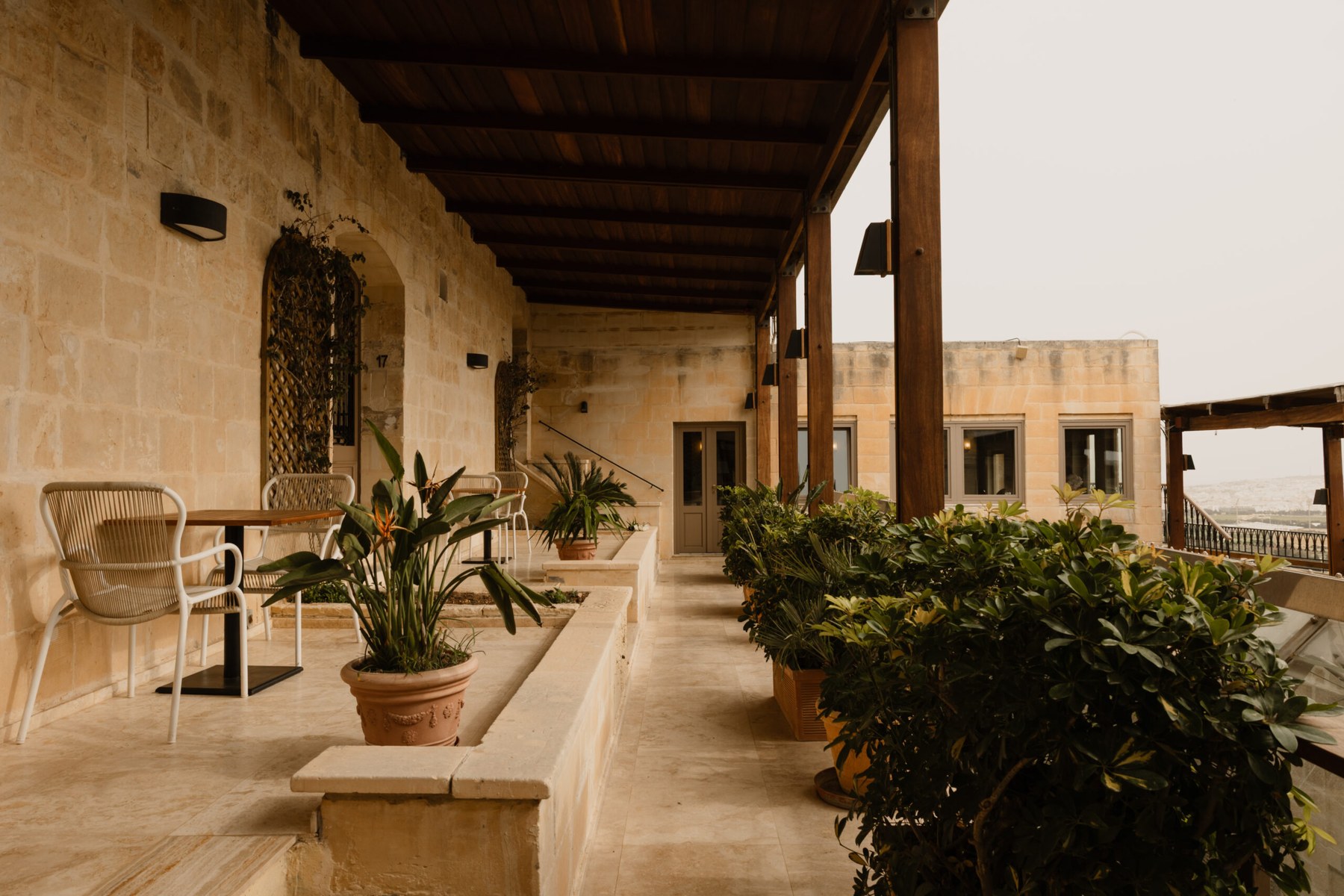 A shaded loggia along the bastion, set with antique furniture and potted plants