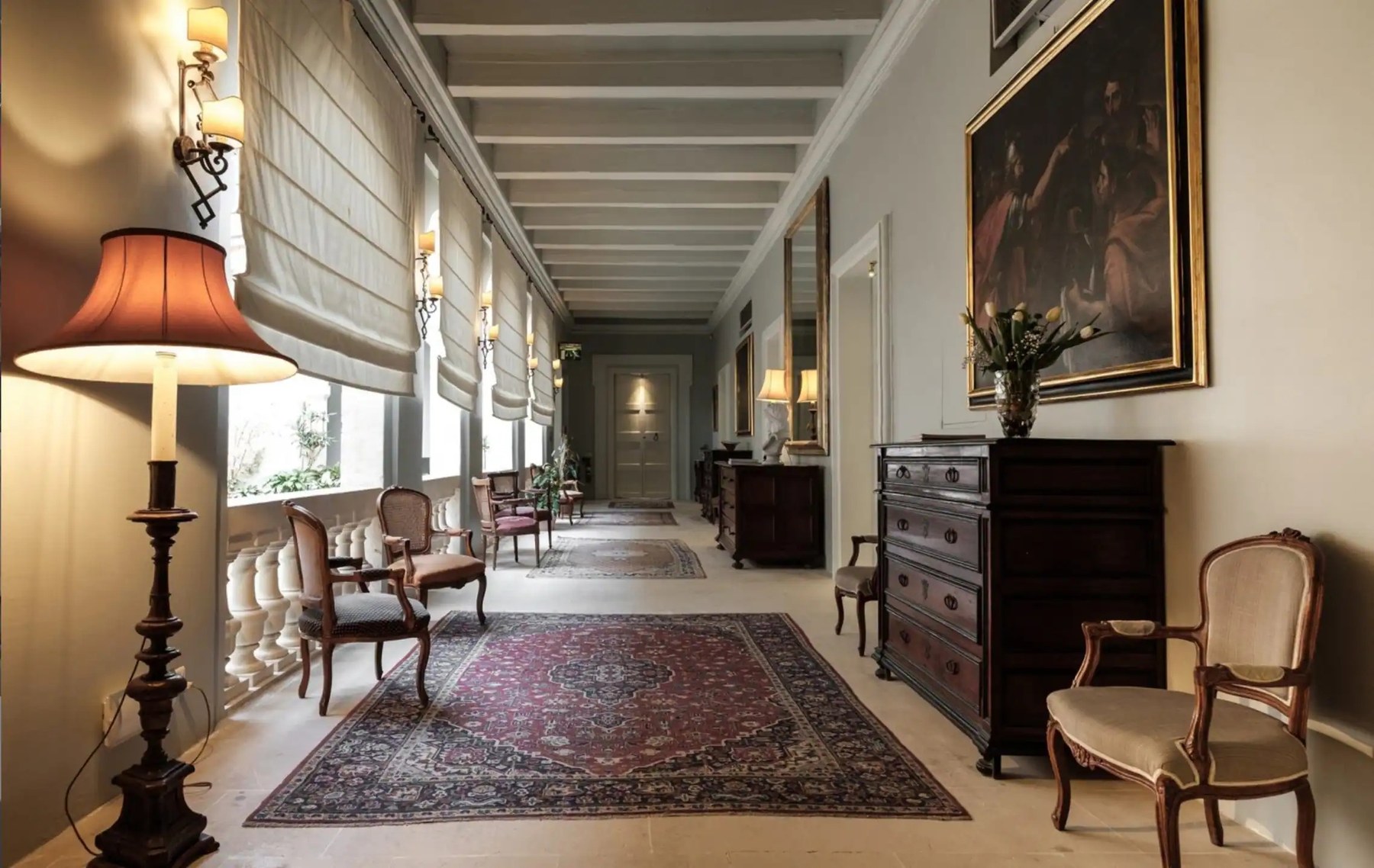 A corridor of the palace hung with oil paintings and antique furniture